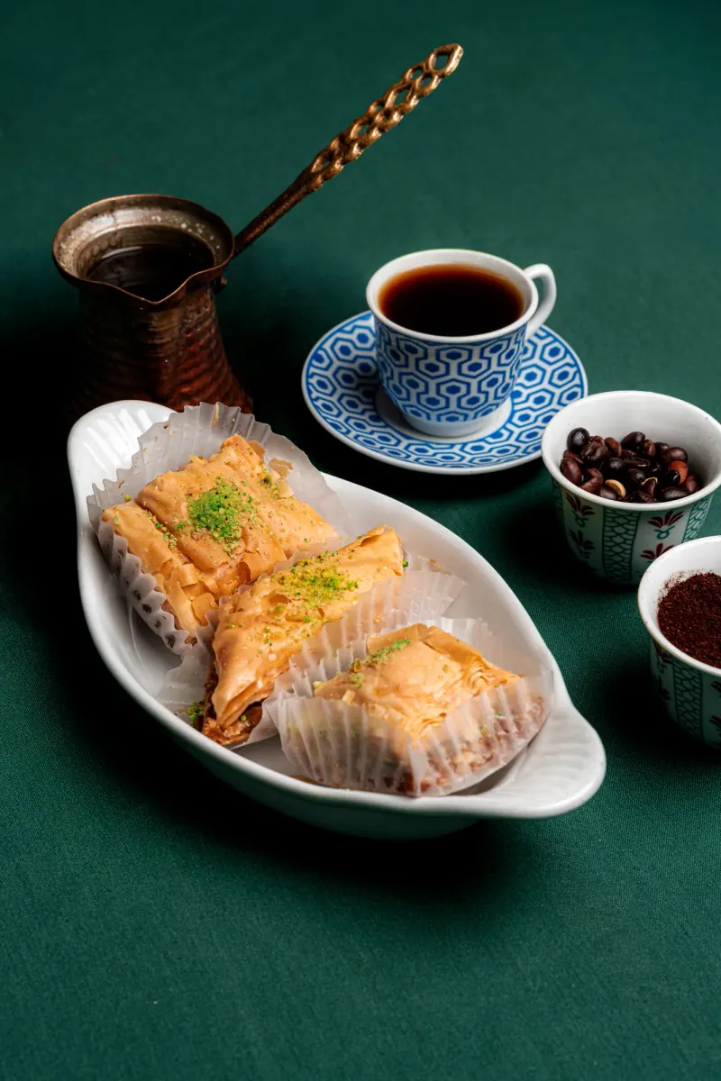 Layered baklava with coffee and a copper pot