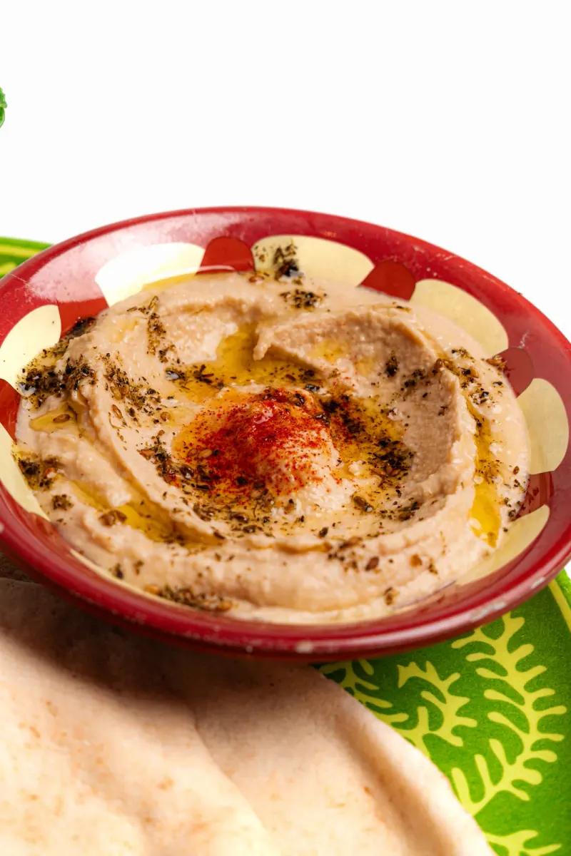 Hummus with oil and red seasoning, and flatbread